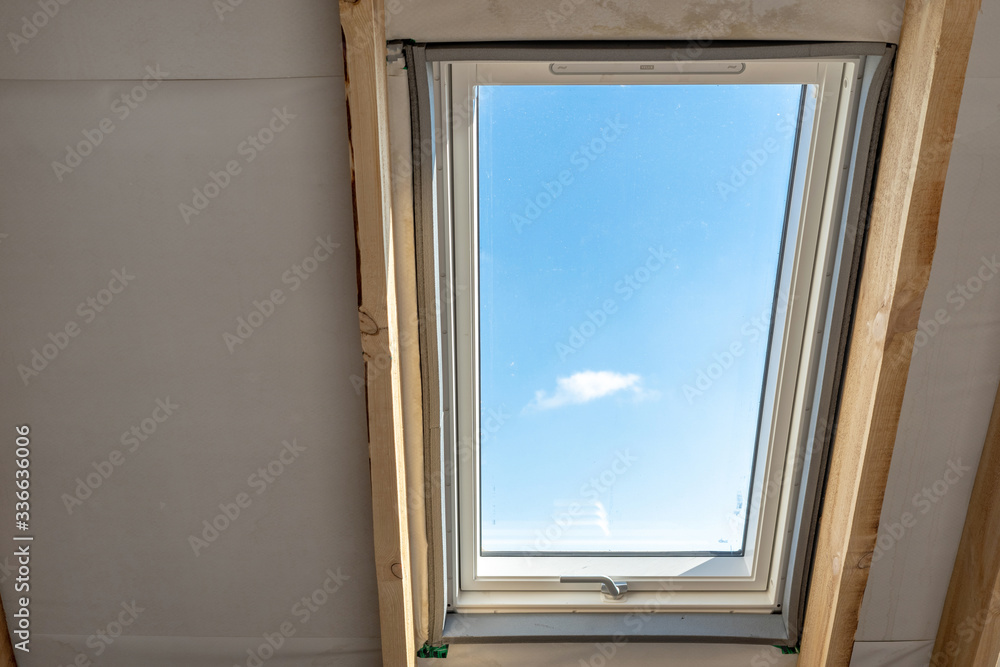 Plastic mansard window with triple glasses and clear view on sky Plastic mansard window with triple glasses and clear view on sky
