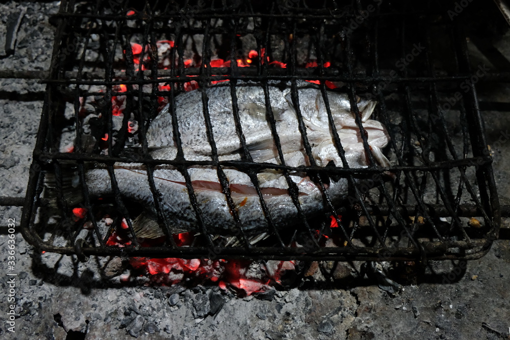 process of making grilled fish using fire from charcoal