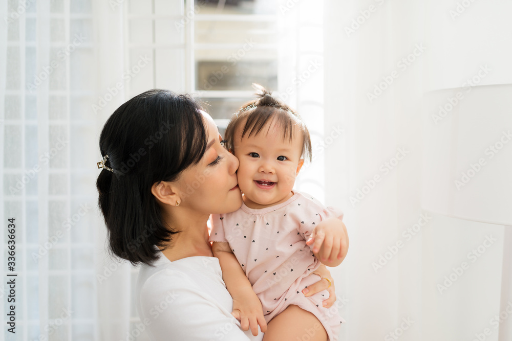 Portrait of happy vietnamese mother hugging with her cute little daughter at home Portrait of happy vietnamese mother hugging with her cute little daughter at home