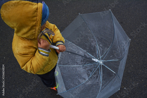 a small boy went for a walk with an umbrella in rainy weather