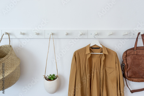 White coat-rack with clothes and accessories