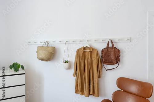 White coat-rack with clothes and accessories