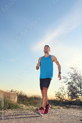 Sport gait. A man in sports outfit gait along the mountain trail.