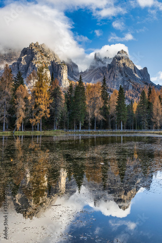 Lake Antorno in Dolomite Alps and colorful trees with reflections in autumn season, Italy