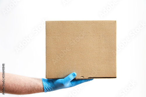 Delivery man holding a box on white background, delivery man in protective gloves