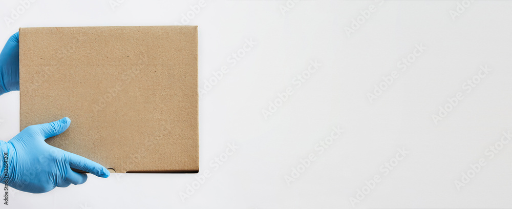 © Delia - Delivery man delivering holding parcel box to customer with security wearing gloves © Delia - Delivery man delivering holding parcel box to customer with security wearing gloves