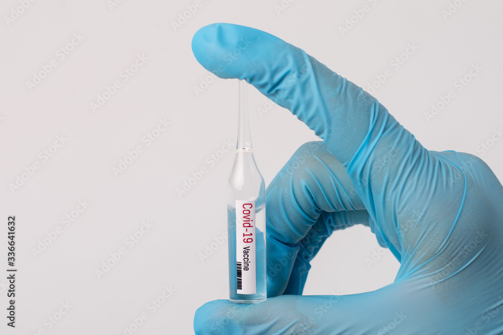 Medical worker with small precious ampule with Covid-19 vaccine. Developing treatment against dangerous virus Medical worker with small precious ampule with Covid-19 vaccine. Developing treatment against dangerous virus