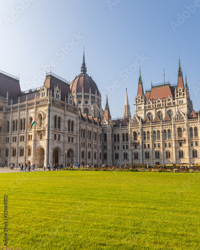 Hungarian Parliament famous building and green lawn on a sunny day, Budapest city