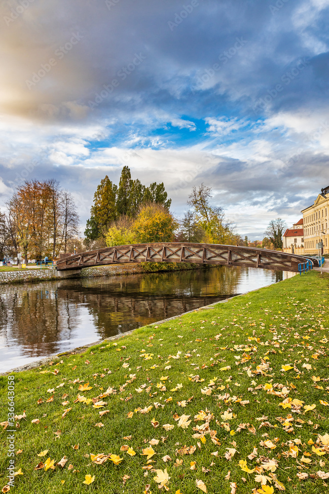 Beautiful evening blue sky and wooden bridge over Vltava river in the park of Ceske Budejovice town in Czech Republic