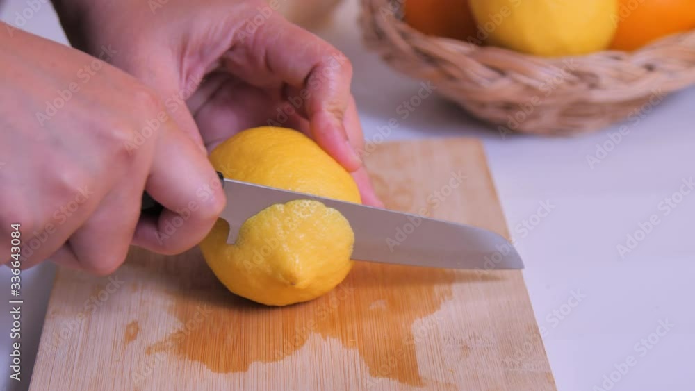 Close-up slice the lemon on the cutting board in the kitchen Close-up slice the lemon on the cutting board in the kitchen