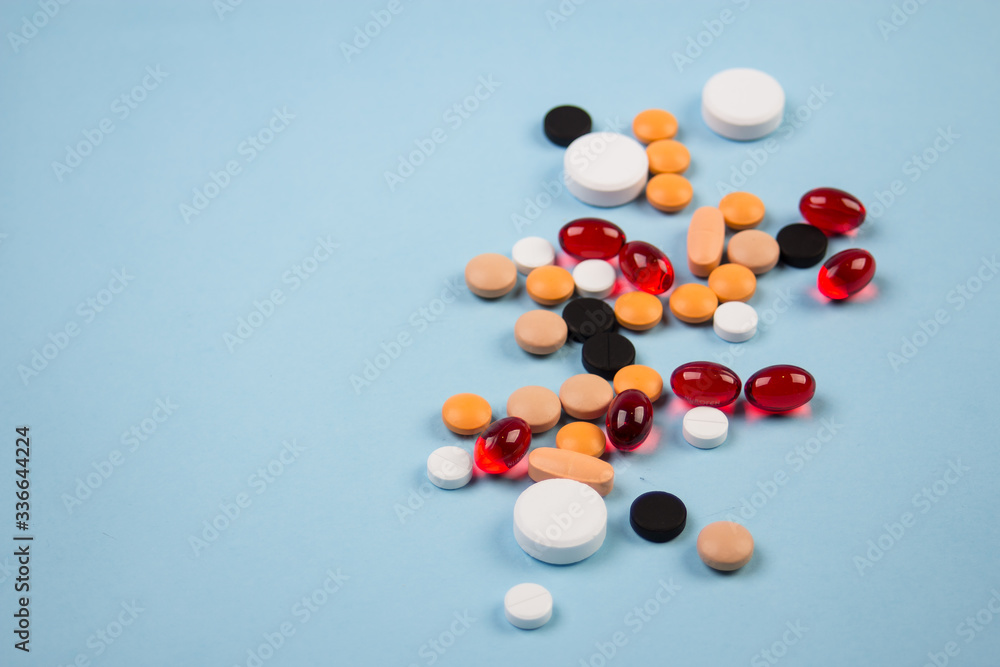 pills of different colors on a blue background pills of different colors on a blue background