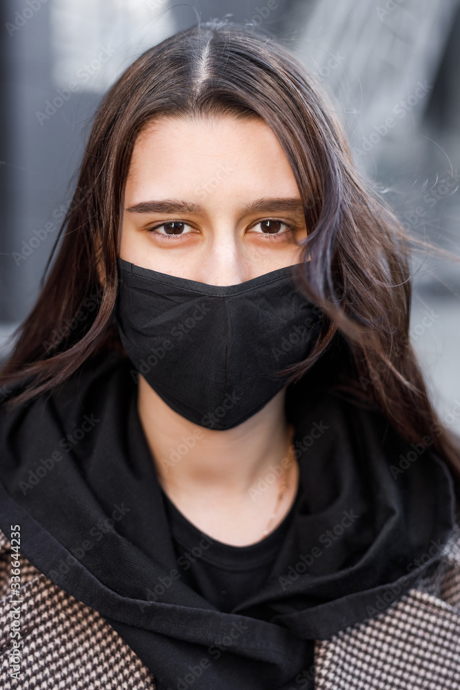 Young woman wearing face mask. Handsome woman in black hoodie wear black medical mask. Pandemic coronavirus covid-19 quarantine period concept. Young woman wearing face mask. Handsome woman in black hoodie wear black medical mask. Pandemic coronavirus covid-19 quarantine period concept.