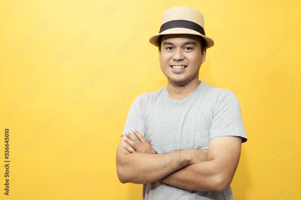 A handsome man in a good mood standing on a yellow background