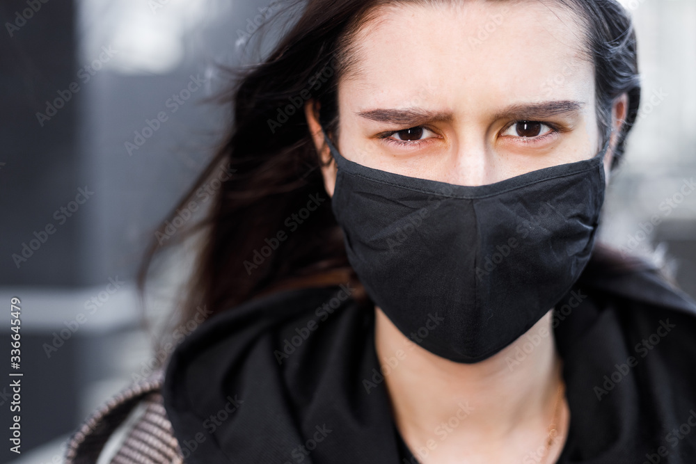 Young woman wearing face mask. Handsome woman in black hoodie wear black medical mask. Pandemic coronavirus covid-19 quarantine period concept. Young woman wearing face mask. Handsome woman in black hoodie wear black medical mask. Pandemic coronavirus covid-19 quarantine period concept.