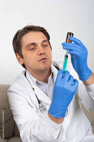 Doctor holding liquid medication and syringe