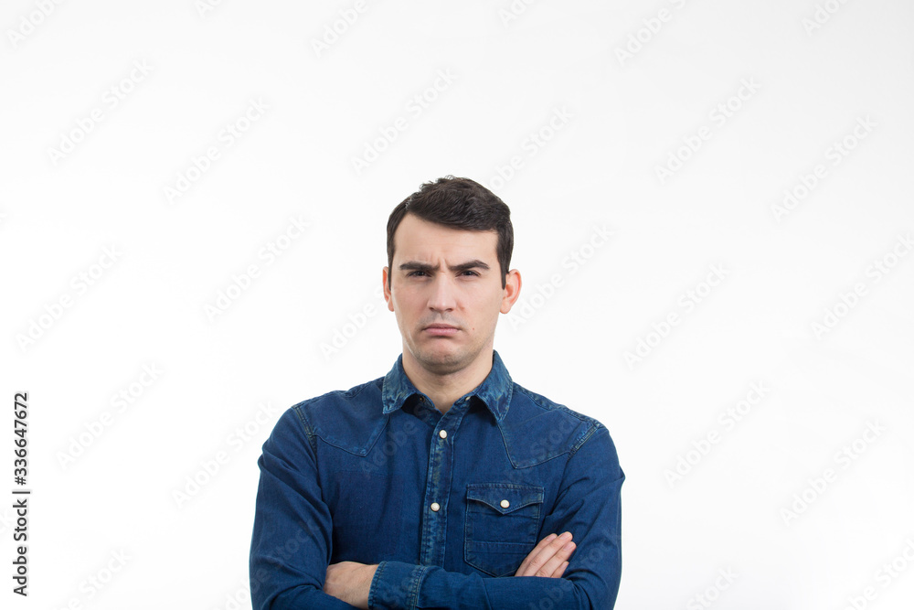Angry serious man looking to camera with crossed hands over white background. Angry serious man looking to camera with crossed hands over white background.