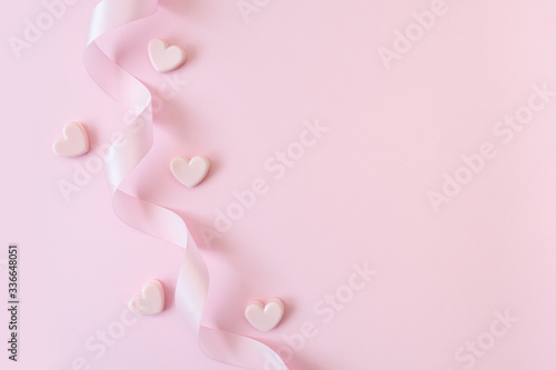 Happy Valentines Day or Mothers Day concept. Pink ribbon and hearts on a pink background with place for your text. For greeting card, banner, poster or web