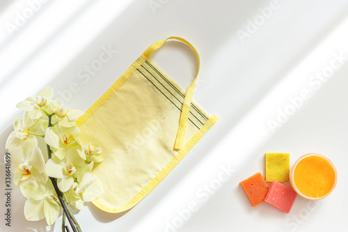 Glove kese and bath soap on white background. Hammam and spa concept. Top view, flat lay, copy space.