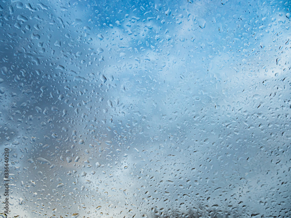 Wet window with rain drops and a cloudy sky outside. Wet window with rain drops and a cloudy sky outside.