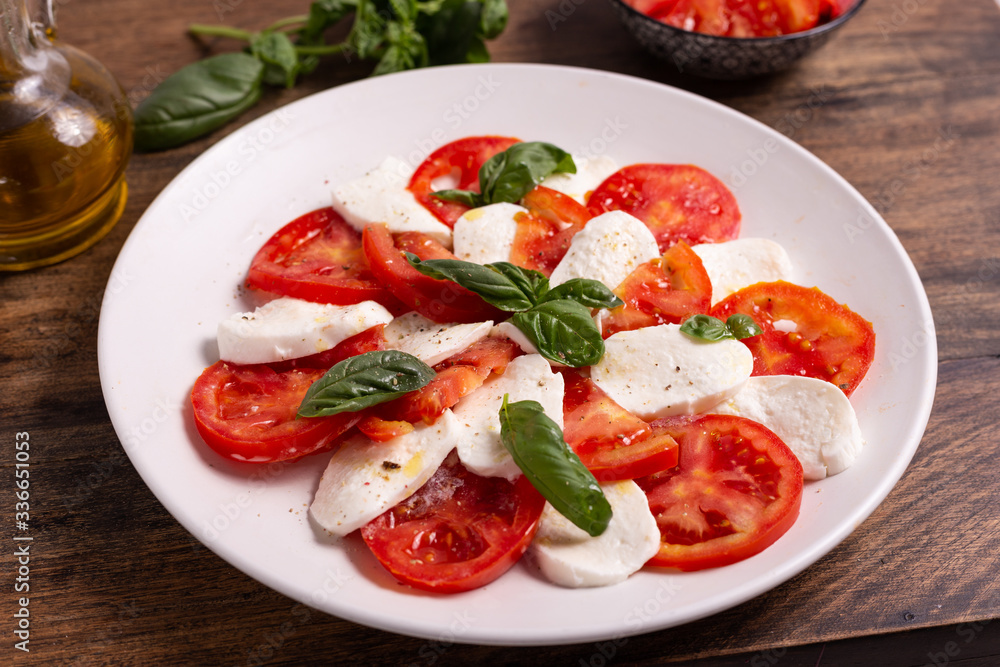 Italian Caprese dish with mozzarella cheese, fresh tomatoes, basil and extra virgin olive oil. Italian food, ideas for fast lunch, summer lunch. Italian Caprese dish with mozzarella cheese, fresh tomatoes, basil and extra virgin olive oil. Italian food, ideas for fast lunch, summer lunch.