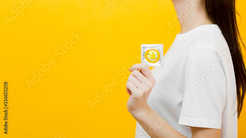 Side view woman holding a condom with copy space
