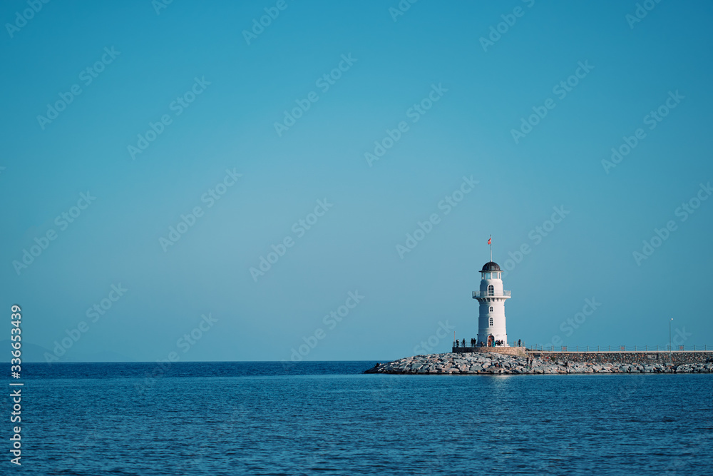 Beautiful seascape. Calm sea and white lighthouse.