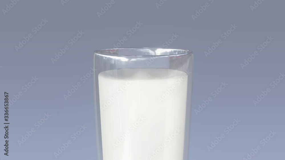slow motion of zooming on the front view of a glass of milk in which falls a drop causing a gush and some waves on the surface, on a light blue background slow motion of zooming on the front view of a glass of milk in which falls a drop causing a gush and some waves on the surface, on a light blue background