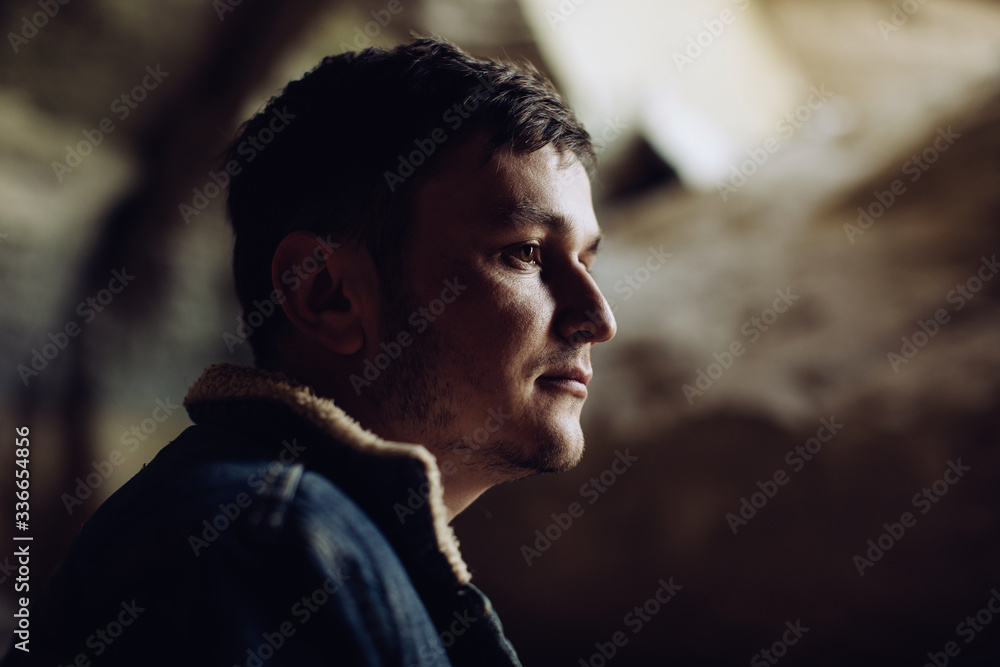 Portrait of a young serious man in the mountains in a cave Portrait of a young serious man in the mountains in a cave