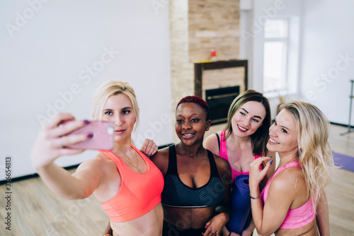 Multiethnic women in sport tops smiling taking selfie