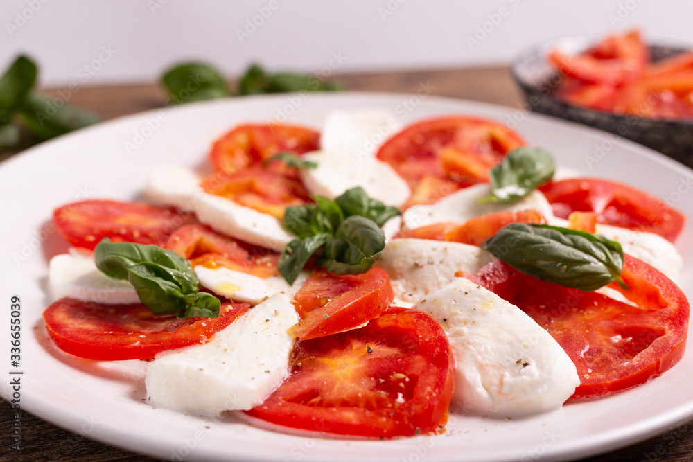 Italian Caprese dish with mozzarella cheese, fresh tomatoes, basil and extra virgin olive oil. Italian food, ideas for fast lunch, summer lunch. Italian Caprese dish with mozzarella cheese, fresh tomatoes, basil and extra virgin olive oil. Italian food, ideas for fast lunch, summer lunch.
