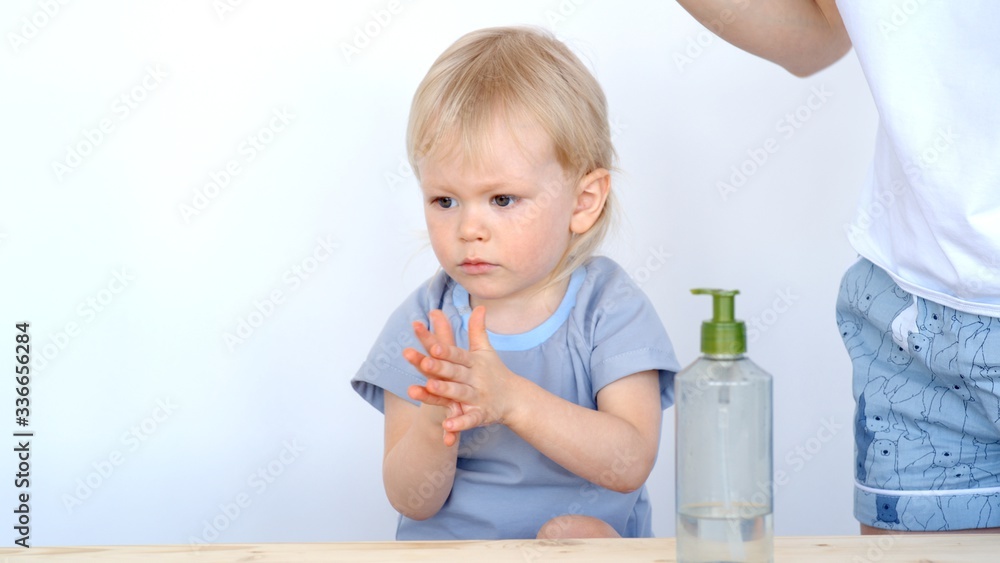 Mom and son washing hands with a disinfectant to prevent infection.