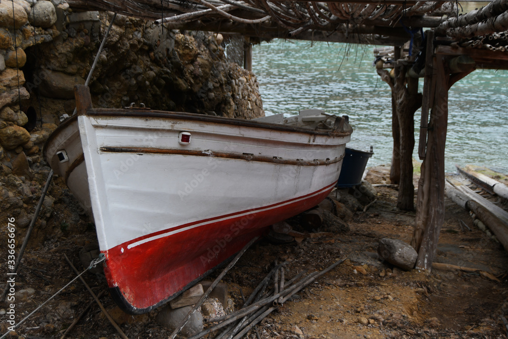 Red and white wooden boat docked next the beach Red and white wooden boat docked next the beach