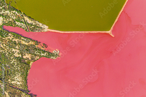 Aerial drone top-down photo of a beautiful natural pink lake located in Torrevieja, Spain. The lake turning into pink by a natural phenomenon and because it has high concentration of salt and algae