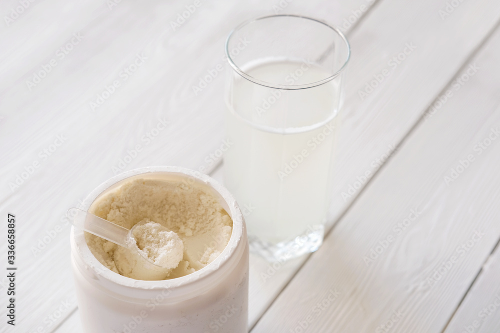 scoop of fish collagen. collagen peptides in container or jar. glass of water for mixing drink. Healthcare supplement concept. collagen powder for skin and joints . scoop of fish collagen. collagen peptides in container or jar. glass of water for mixing drink. Healthcare supplement concept. collagen powder for skin and joints .