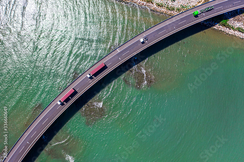 Aerial drone top-down photo of a bridge and trucks going towards the port to ship the containers to be exported out of the country near the port of Valencia in spain