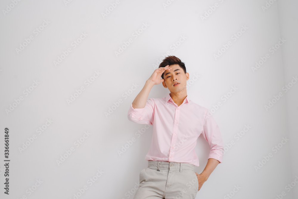 Young Asian man wearing pink shirt standing over white background Young Asian man wearing pink shirt standing over white background
