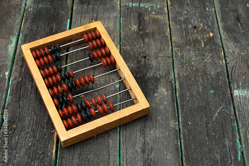 Old wooden abacus on a wooden background with place for your text.