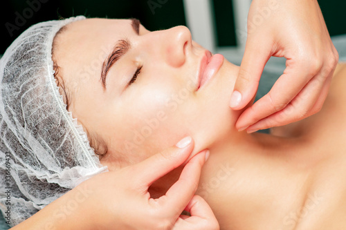 Chin massage of woman young woman during face massage at beauty salon.