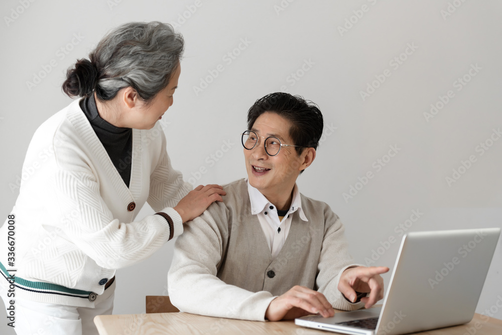 Obraz premium Asian seniors using computers at the desk