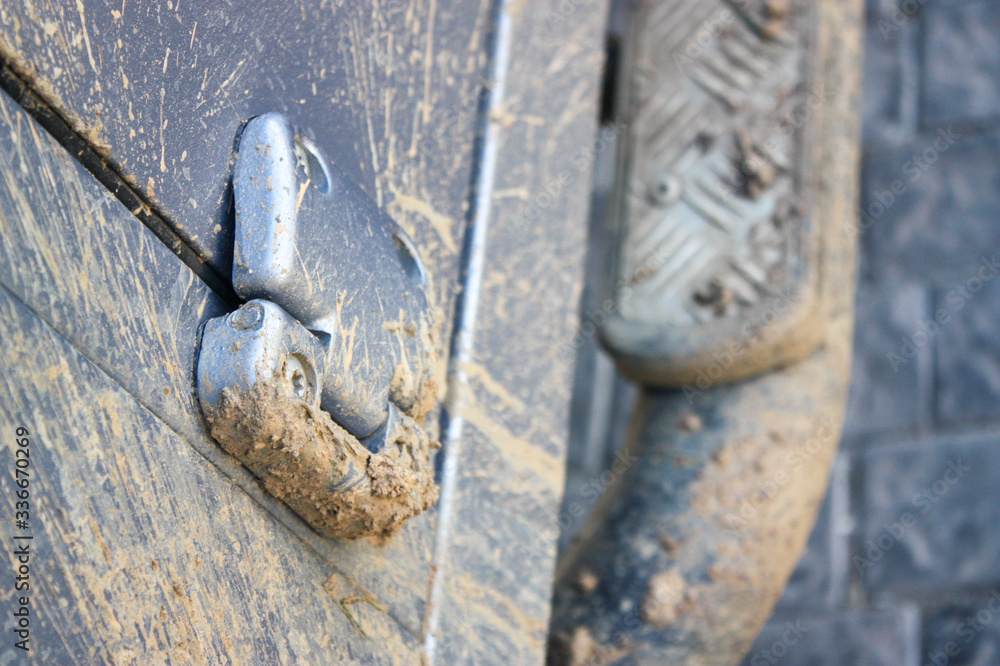 Close up of muddy 4x4 door hinge