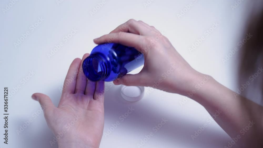 Woman pours pills from a jar into her hand. Pharmaceuticals and Medicines Woman pours pills from a jar into her hand. Pharmaceuticals and Medicines