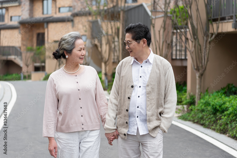 Fototapeta premium An Asian elderly couple walking in the community