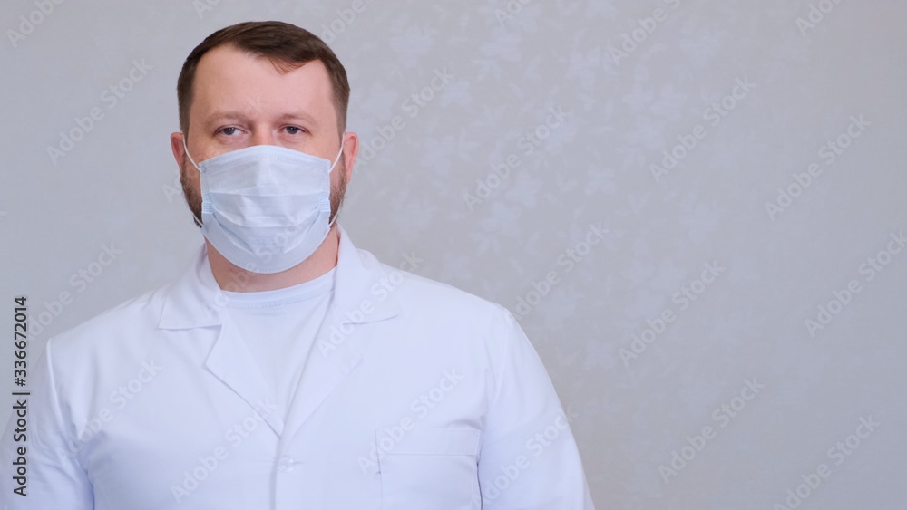 man in a protective mask and a white shirt looks at the camera, close-up. Hygiene concept. prevent the spread of germs and bacteria and avoid infection with the crown virus. copy space