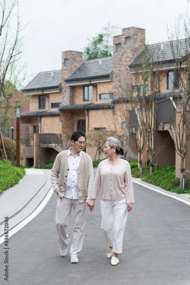 An Asian elderly couple walking in the community