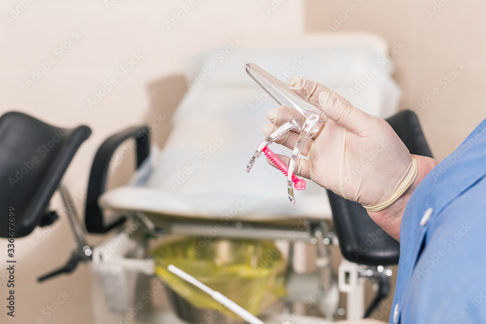 Close-up of doctor hand holds gynecological examination instruments. Gynecologist working in the obstetrics and gynecology department. Medical concept.