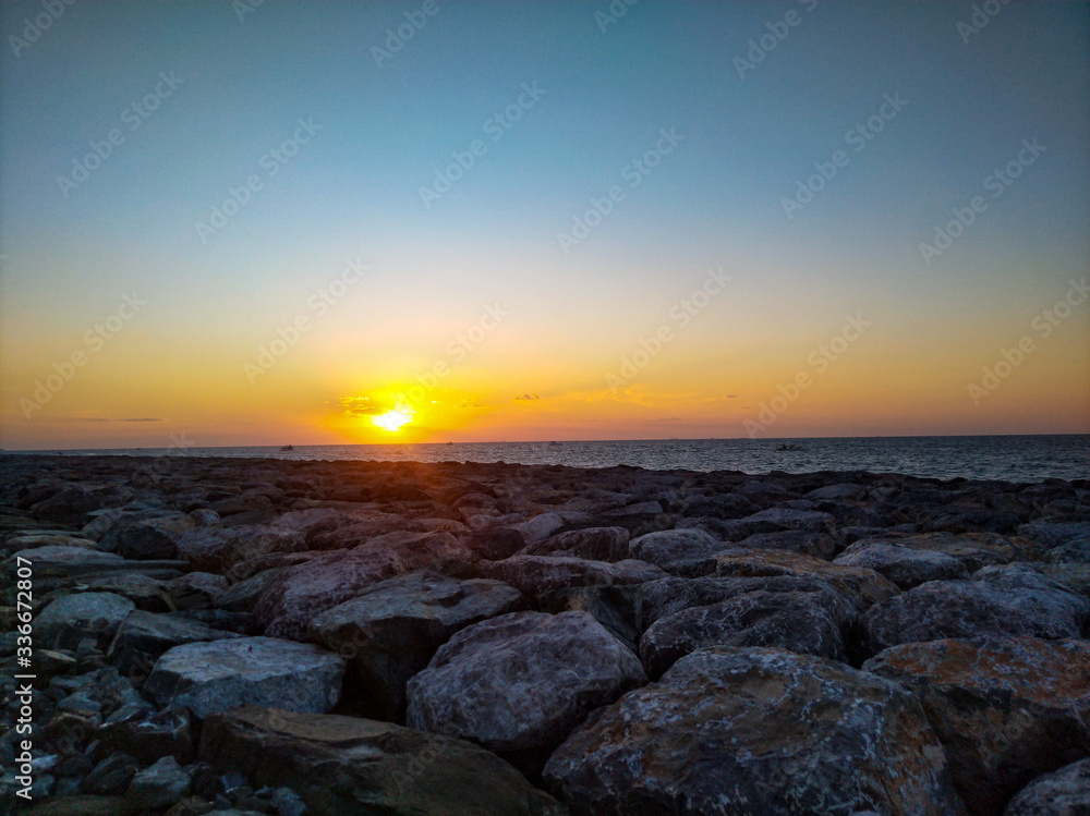 Sunset in Dubai in the summer. Big stones near the sea.