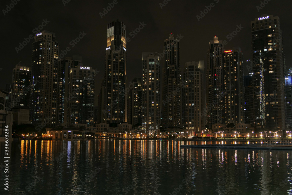 Obraz premium Dubai skyscrappers in the night. Reflection from the river.
