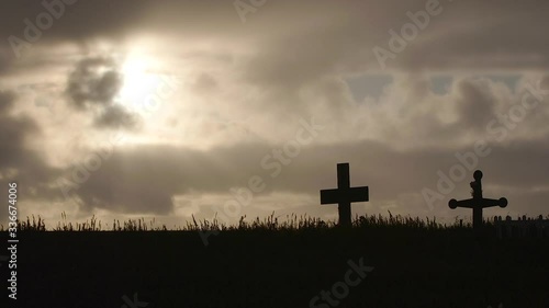 Silhouetted wooden crosses at the cemetery in Kivalina, Alaska. Medium Shot photo