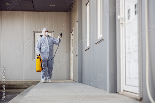 Cleaning and Disinfection outside around buildings, the coronavirus epidemic. Professional teams for disinfection efforts. Infection prevention and control of epidemic. Protective suit and mask.