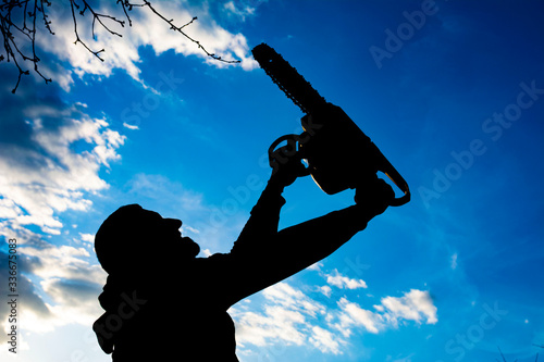 Silhouette of a man with a chainsaw